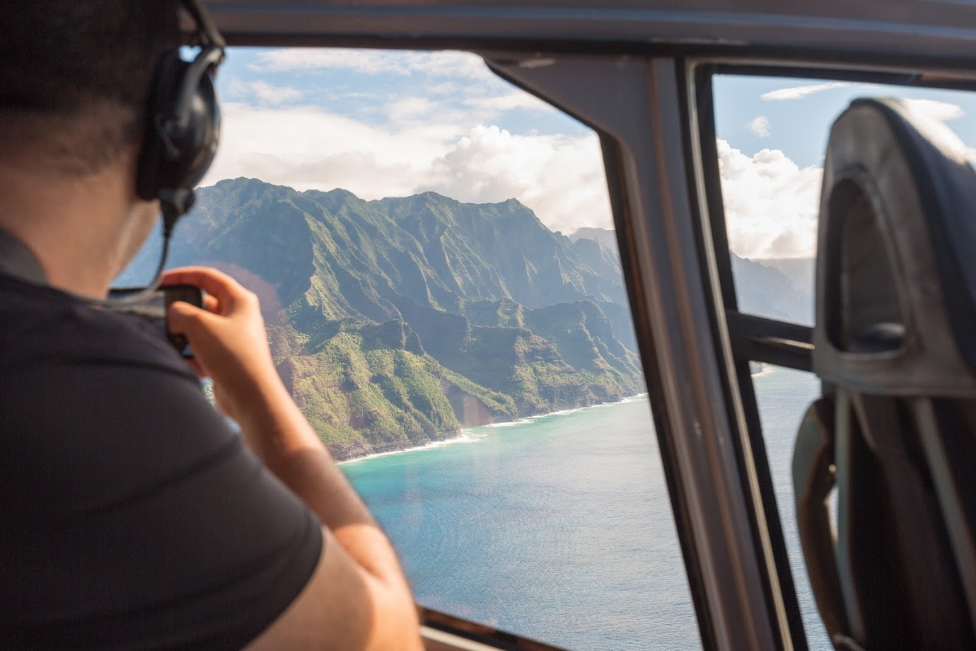 Napali coast from a helicopter with a tourist taking pictures - Kauai, Hawaii